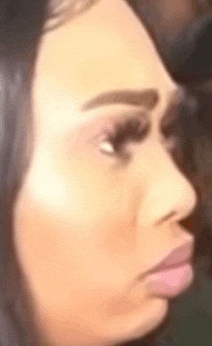 a close up of a woman 's face with a slight smirk on her face .