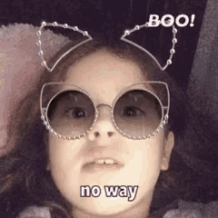 a little girl wearing cat ears and sunglasses says boo no way .