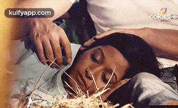 a man is putting his hand on a woman 's forehead while she sleeps .