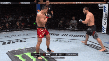 two men are fighting in a ufc ring with a monster energy drink in the foreground