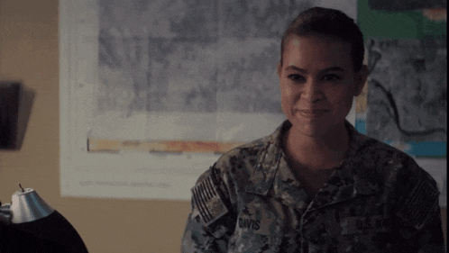 a woman in an u.s. army uniform is smiling