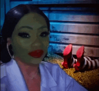 a woman with a green mask on her face is standing next to a person wearing red shoes .