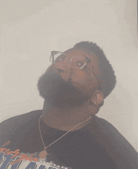 a man with glasses and a beard looks up at something