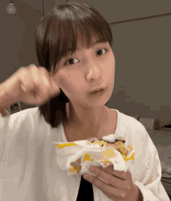 a woman in a white shirt is holding a bag of food