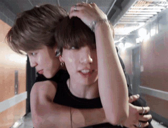 a couple of men hugging each other in a hallway .