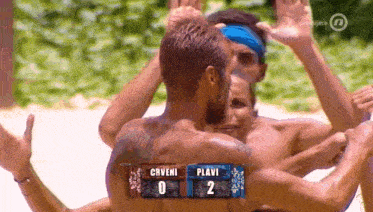 a group of men hugging each other with a scoreboard that says plavi on it