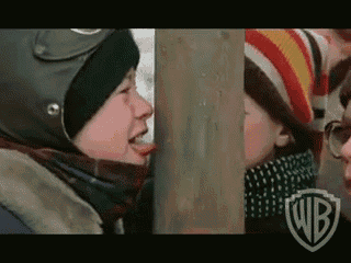 a boy wearing a helmet is sticking his tongue out in front of a wooden post with the wb logo on it