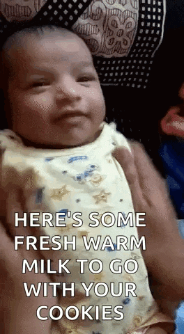 a baby is being held in a person 's arms and the baby is looking at the camera .