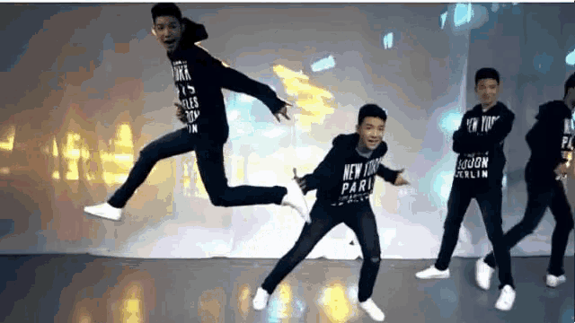 a group of young men wearing new york paris sweatshirts are dancing