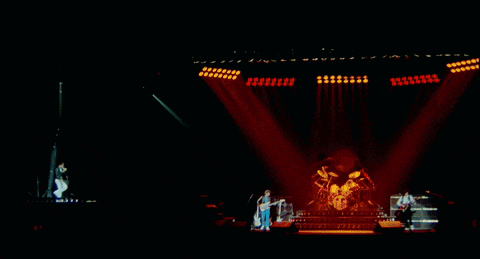 a group of people playing instruments on a stage with a lot of lights
