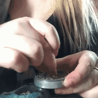 a close up of a woman grinding a cigarette