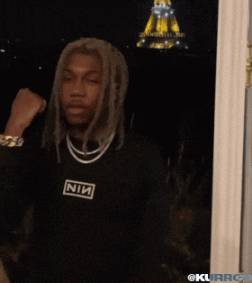 a man with dreadlocks is wearing a black shirt that says nin on it