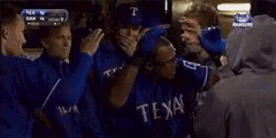 a man wearing a texas baseball jersey walks in a dugout