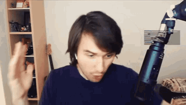 a man is standing in front of a microphone while wearing a pair of ear buds