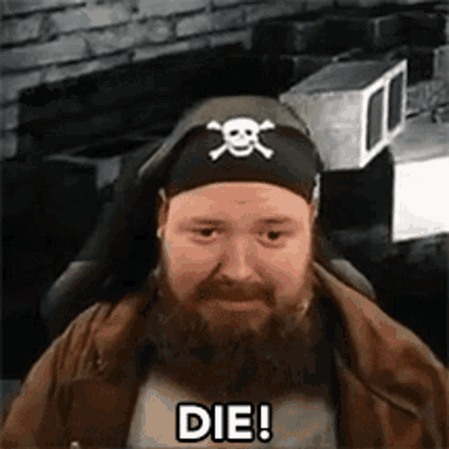 a man with a beard wearing a headband with a skull and crossbones on it says `` die '' .