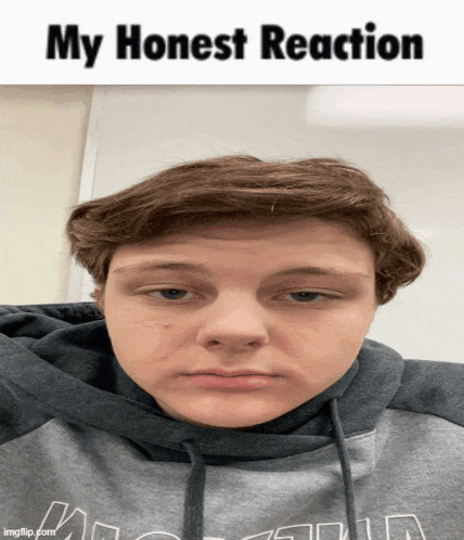 a young man wearing a grey hoodie with the words " my honest reaction " on the top
