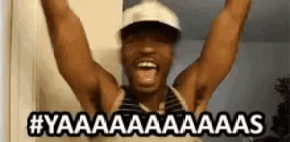 a man wearing a hat is raising his arms in the air and shouting .