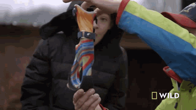 a person holding a colorful item with a national geographic logo in the corner
