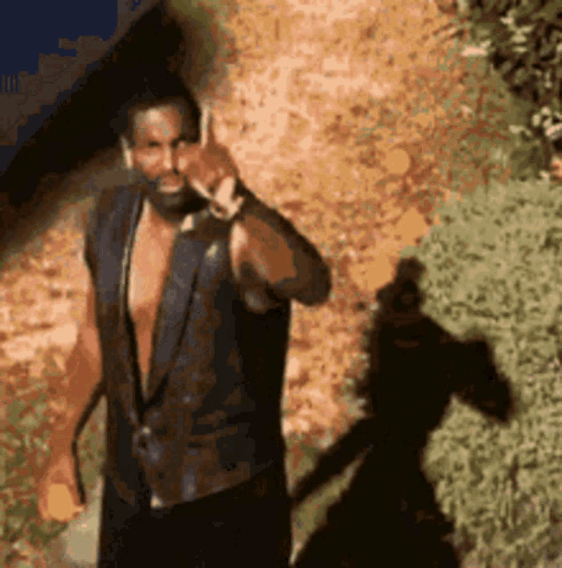 a man without a shirt is talking on his cell phone