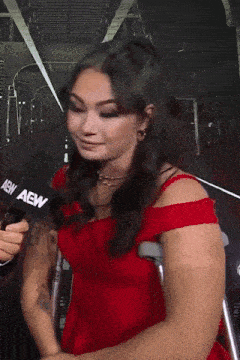 a woman wearing crutches and a red dress looks at the camera