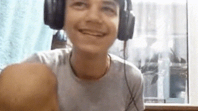 a young man wearing headphones is taking a selfie .