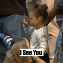 a little girl standing next to a dog with a sign that says i see you .