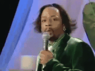 a man in a green suit is holding a microphone in his hand