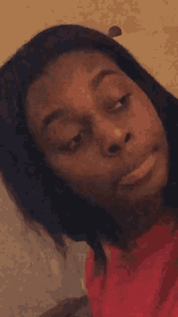 a woman with her eyes closed is wearing a pink shirt