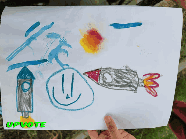 a child 's drawing of a rocket is being held up by a person