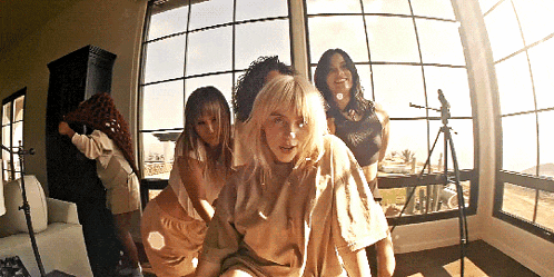 a group of women are posing for a photo in front of a window
