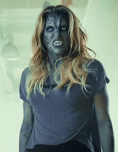 a woman with blue paint on her face is standing in a dark room