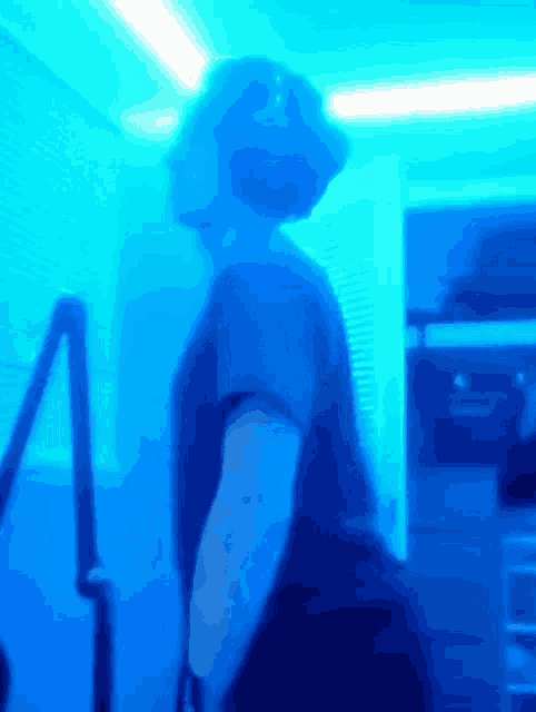 a blurry picture of a person standing in a room with blue lights