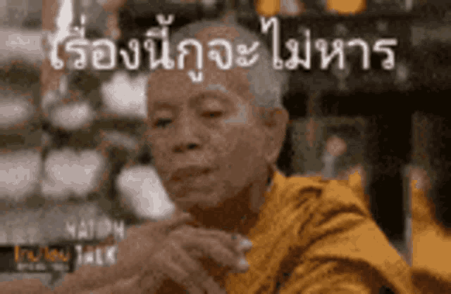 a man in a yellow robe is sitting in front of a sign that says ' nation talk ' on it