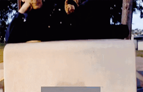 a person is sitting on a concrete block with a sign that says ' i 'm sorry ' on it