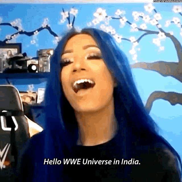 a woman with blue hair is laughing and saying hello wwe universe in india