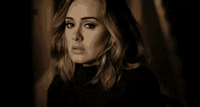 a close up of a woman 's face in a dark room looking at the camera .