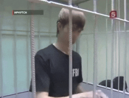 a man in a fbi shirt is in a jail cell