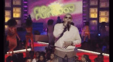 a man is singing into a microphone in front of a screen that says 80 's boy on it