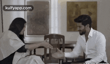 a man and a woman are sitting next to each other in a room .
