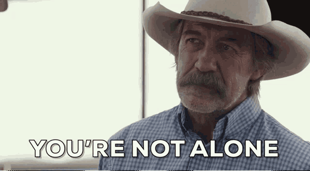 a man wearing a cowboy hat and plaid shirt says you 're not alone
