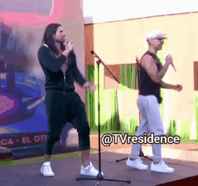 two men singing and dancing on a stage with the words @tvresidence written on the bottom