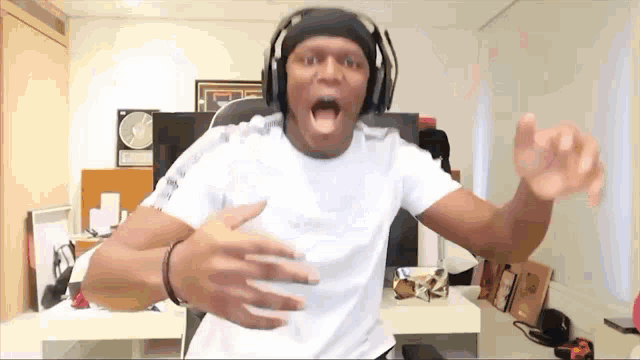 a man wearing headphones and a headband is dancing in a room .