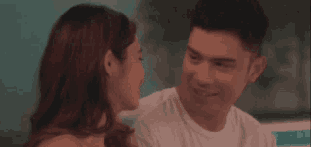 a man and a woman are looking at each other .
