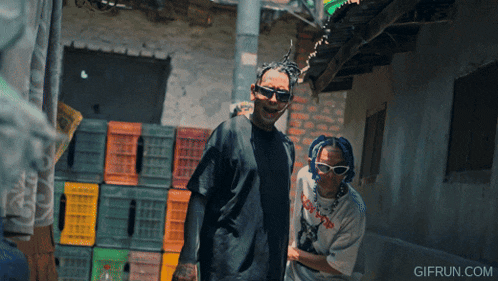 a gif from gifrun.com shows two people standing next to each other in front of crates