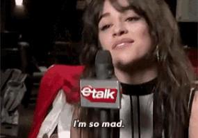 a woman is talking into a microphone with the words `` i 'm so mad '' written on it .