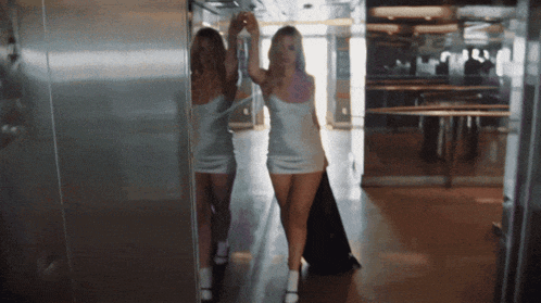 a woman in a white dress is standing in a hallway
