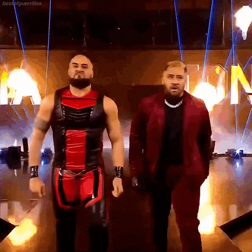 two wrestlers are standing next to each other in front of a sign that says best of guerrillas
