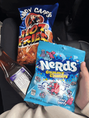a person holding a bag of nerds gummy clusters