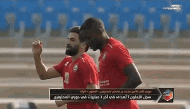 two men are playing soccer on a field .
