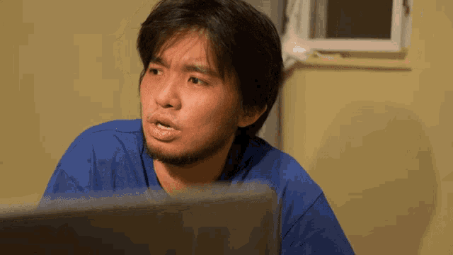 a man in a blue shirt is looking at something